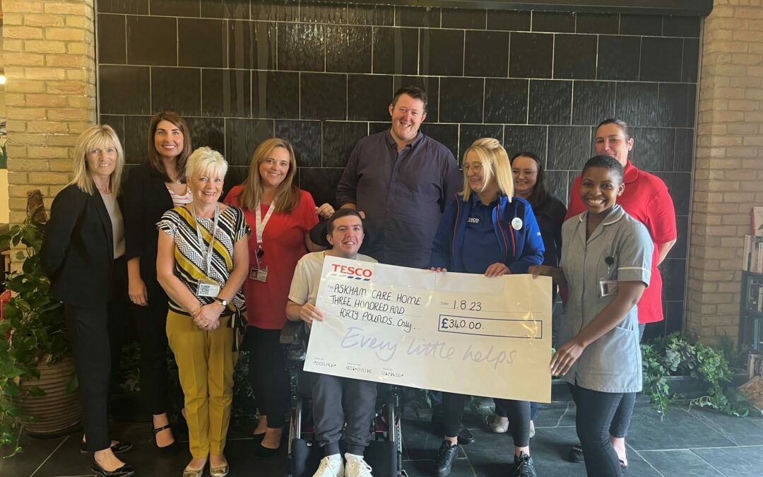 The Askham residents and staff members receiving a £340 donation from Kelly in the Community.